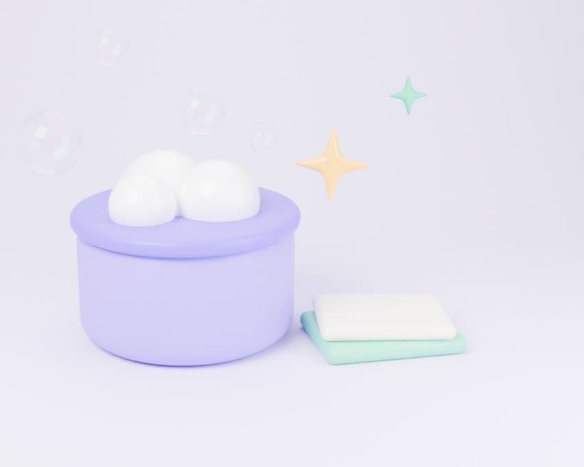 Clay-style illustration of a lilac bucket full of foam beside folded mint and cream cloths