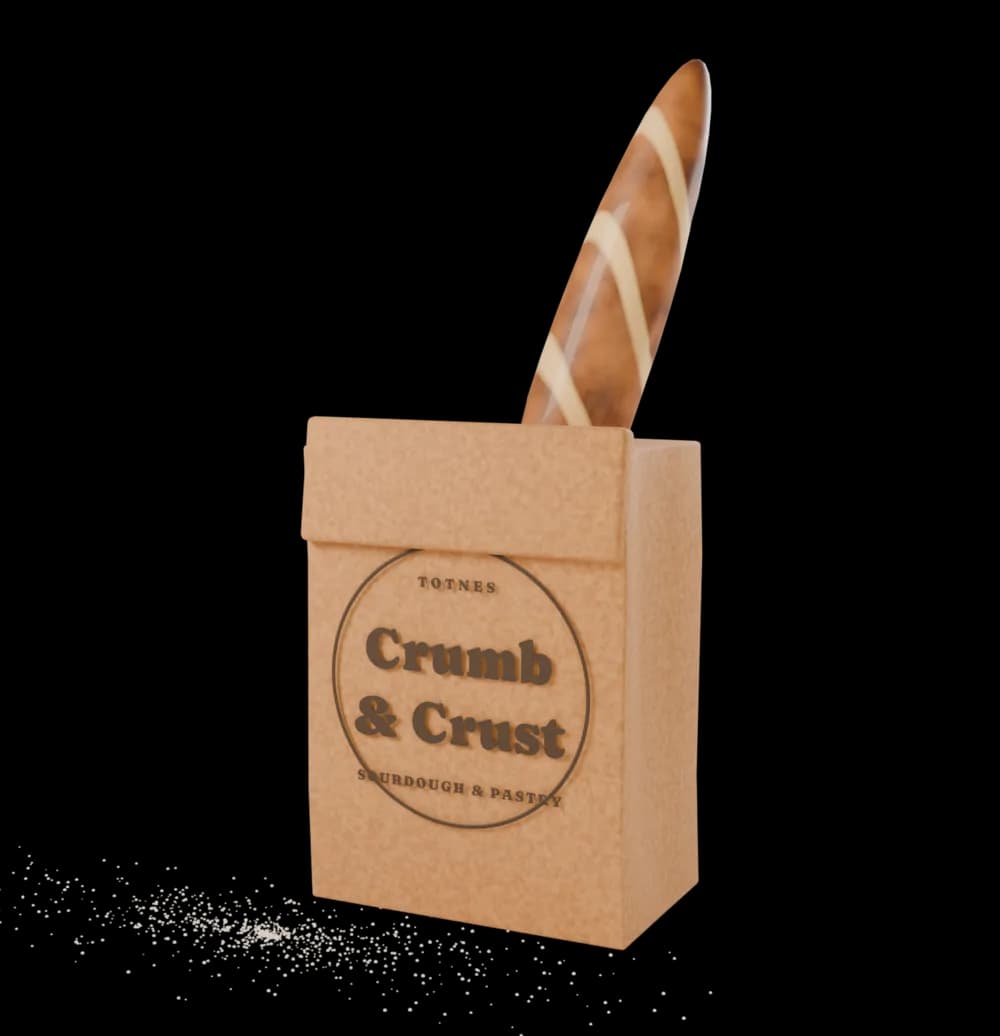 A kraft paper bakery bag printed with the Crumb & Crust stamp, a baguette standing out of it and flour dusted on the counter