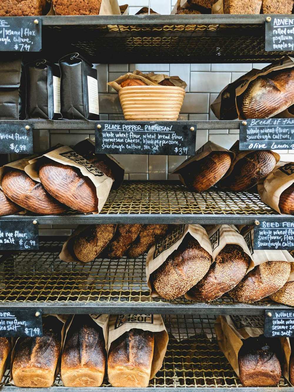 Wire racks of loaves in paper bags with chalk price labels