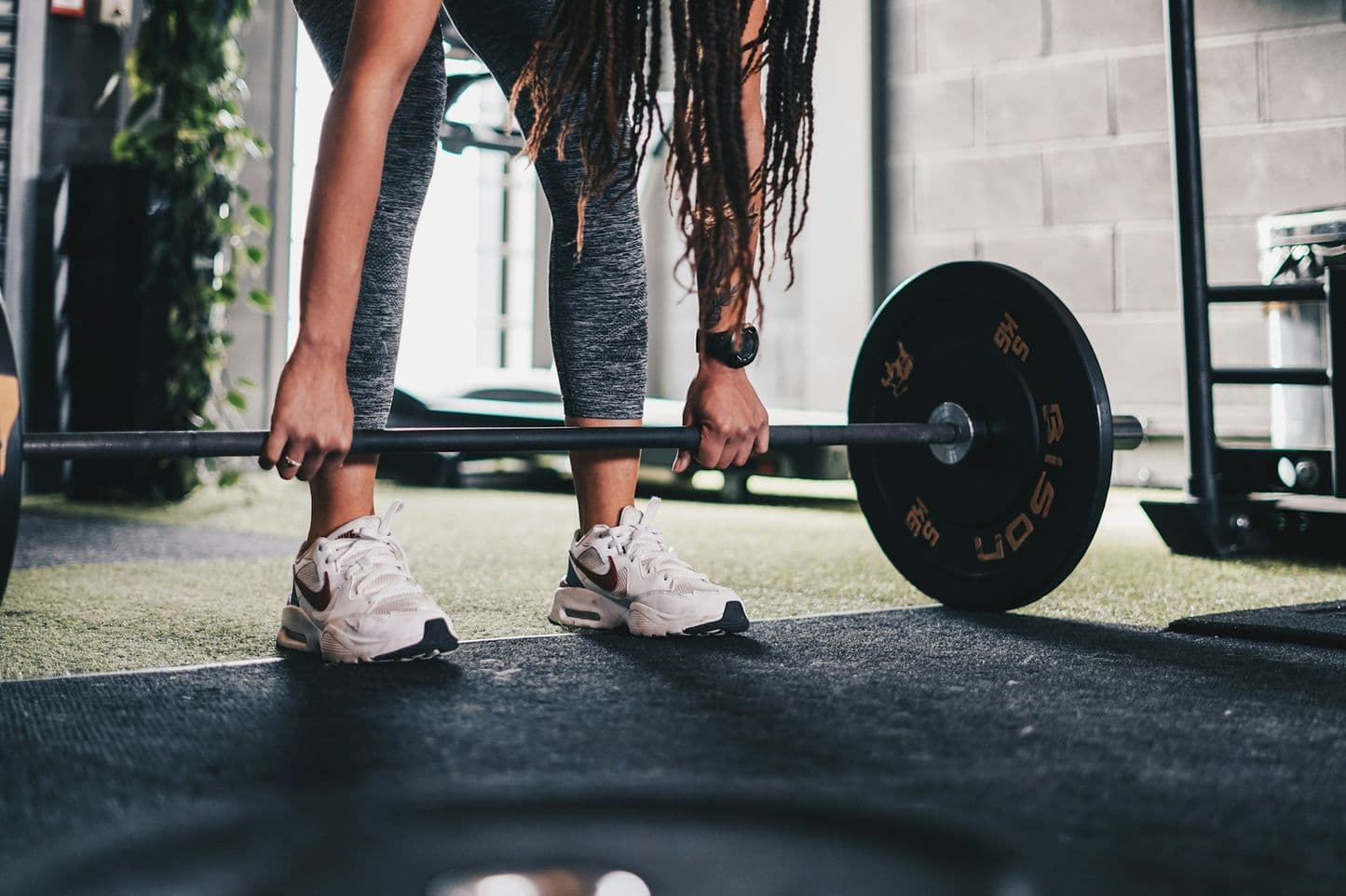 A member setting up a barbell deadlift on the platform
