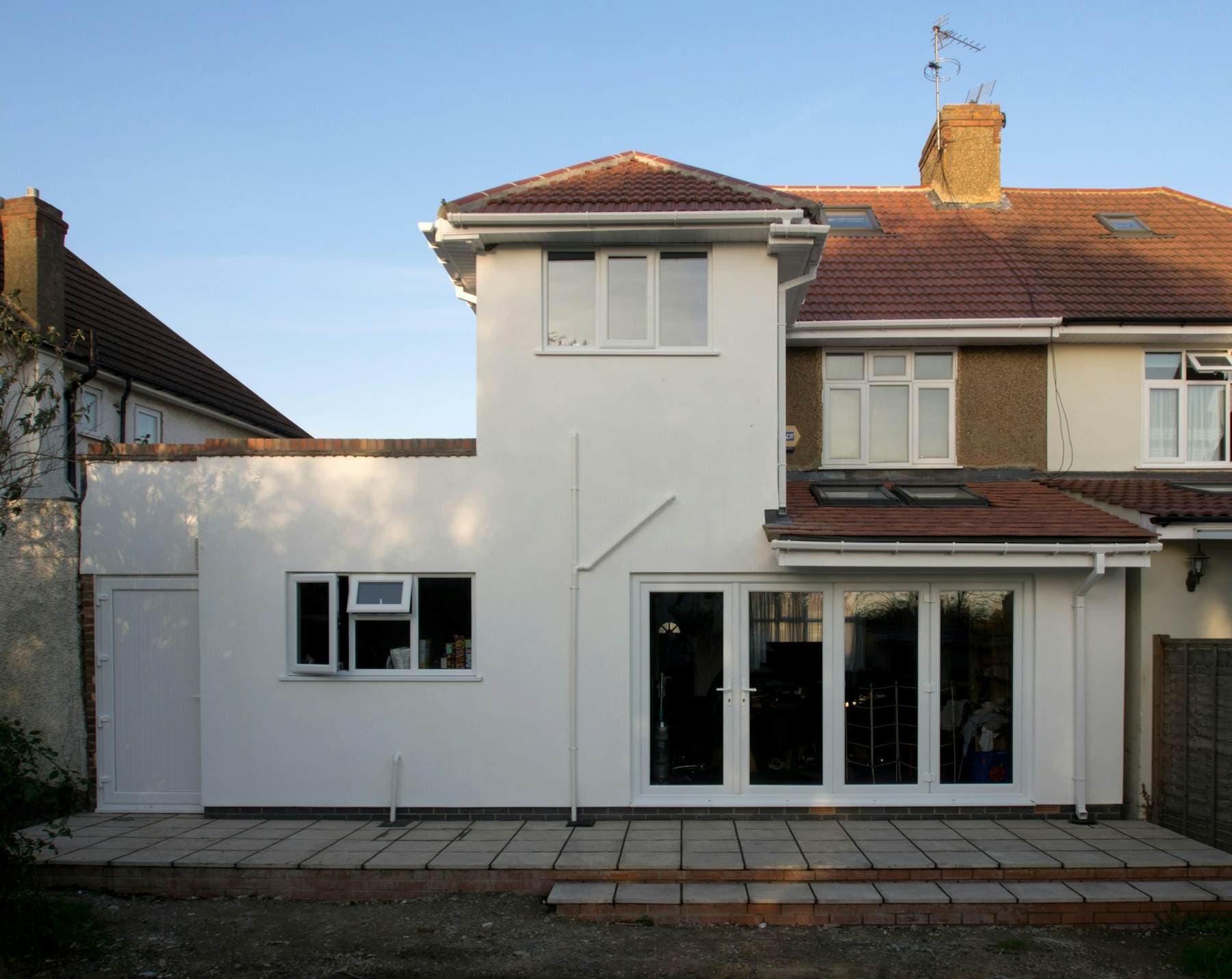A rendered white rear extension with French doors on a 1930s semi-detached house