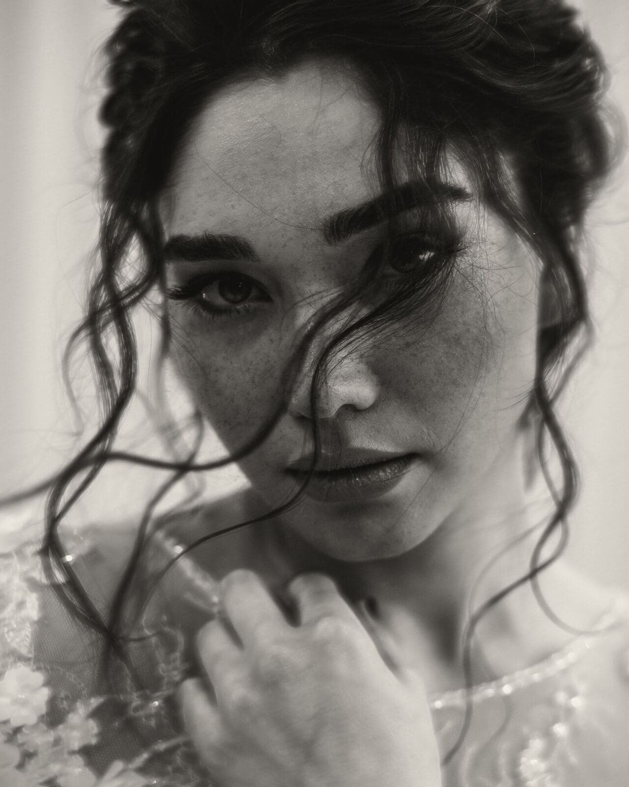 A bride with windswept hair looks straight into the camera