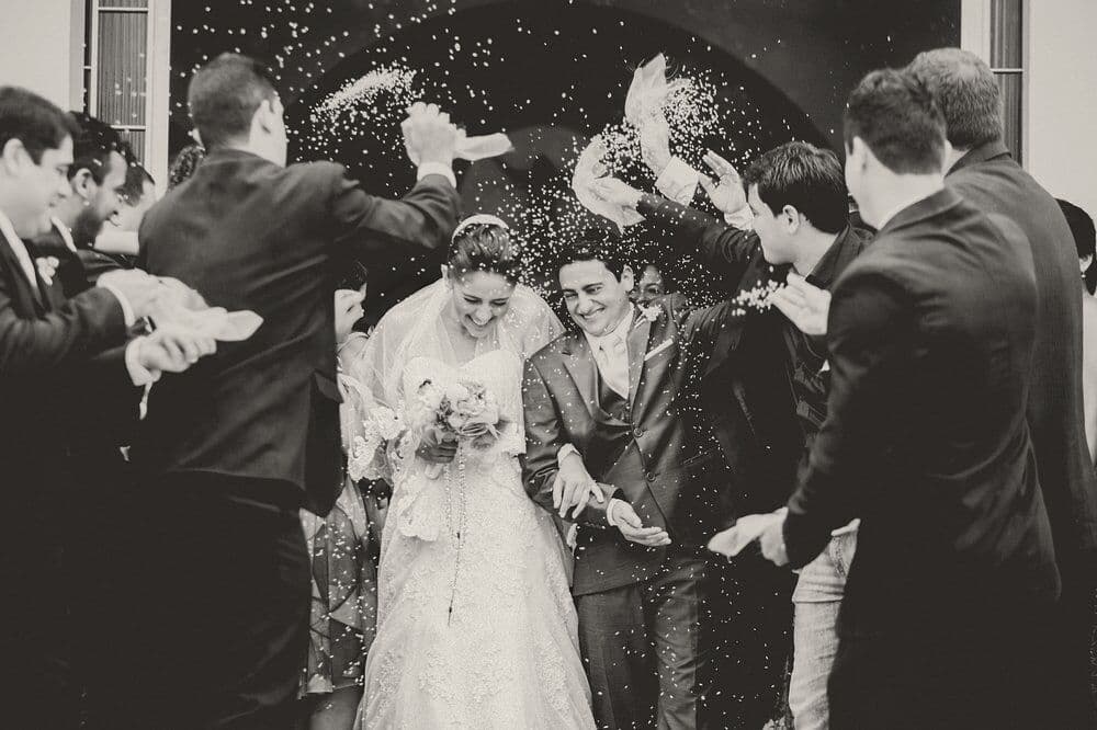 Guests throw confetti over the couple as they leave the ceremony