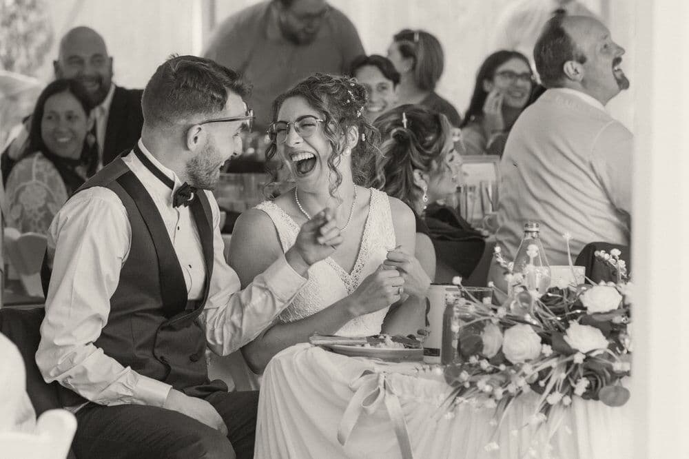 The couple laughing during the speeches