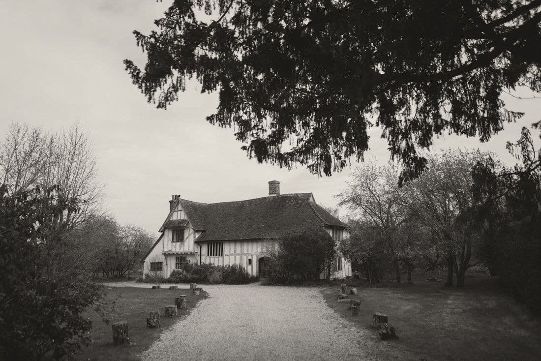 A timber-framed country house at the end of a gravel drive