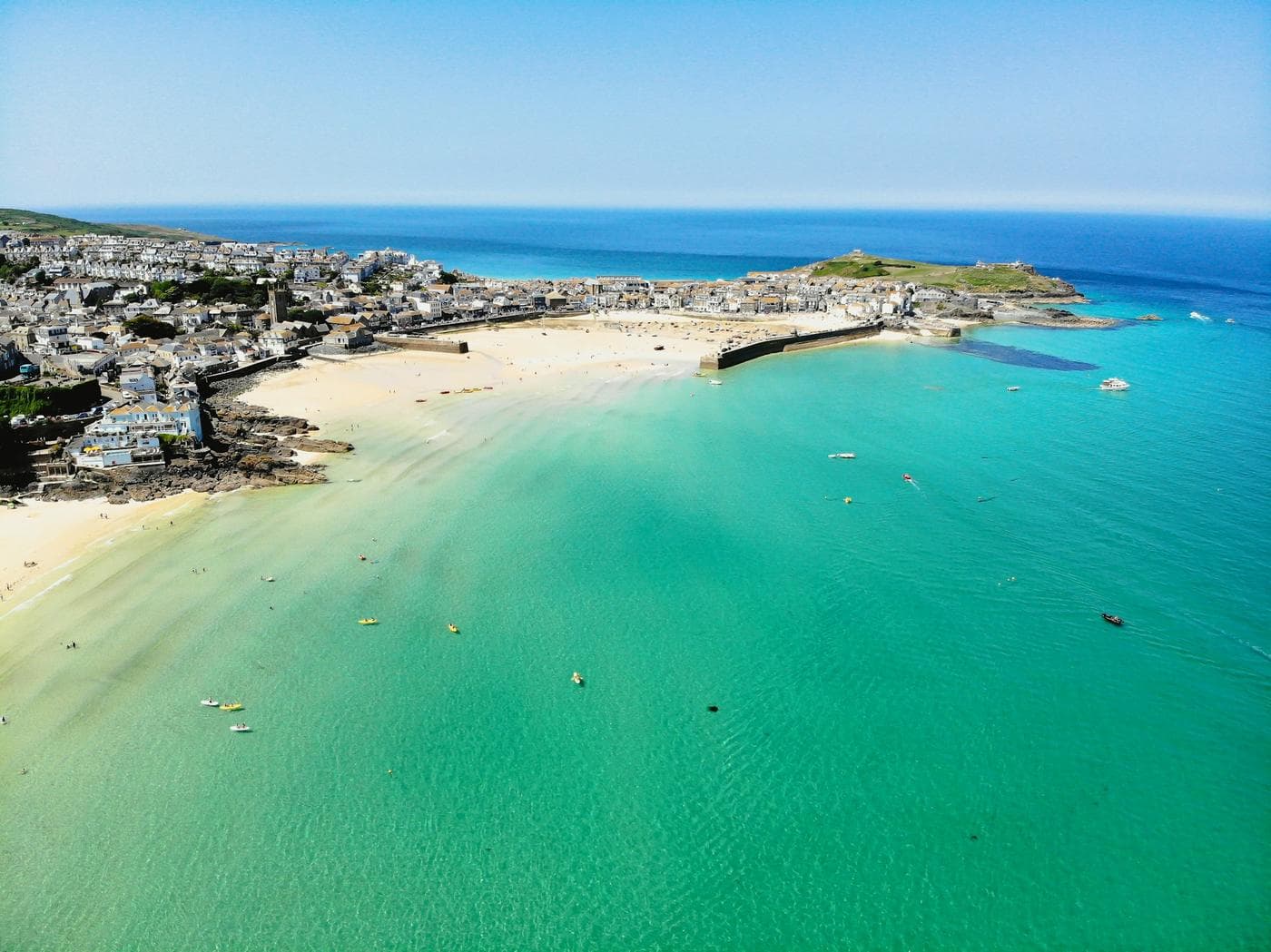 Aerial view of a turquoise bay and a long white sand beach beside the town