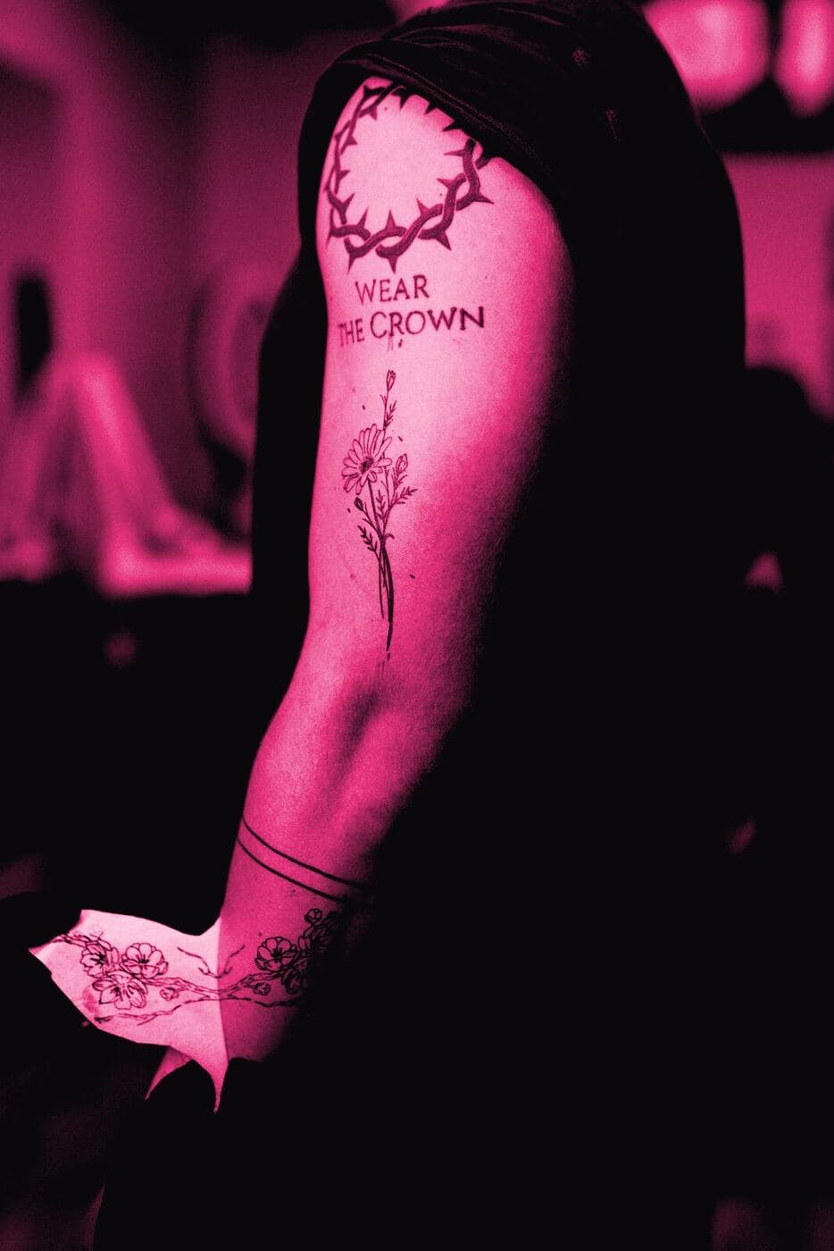 A healed fine-line floral tattoo on an upper arm