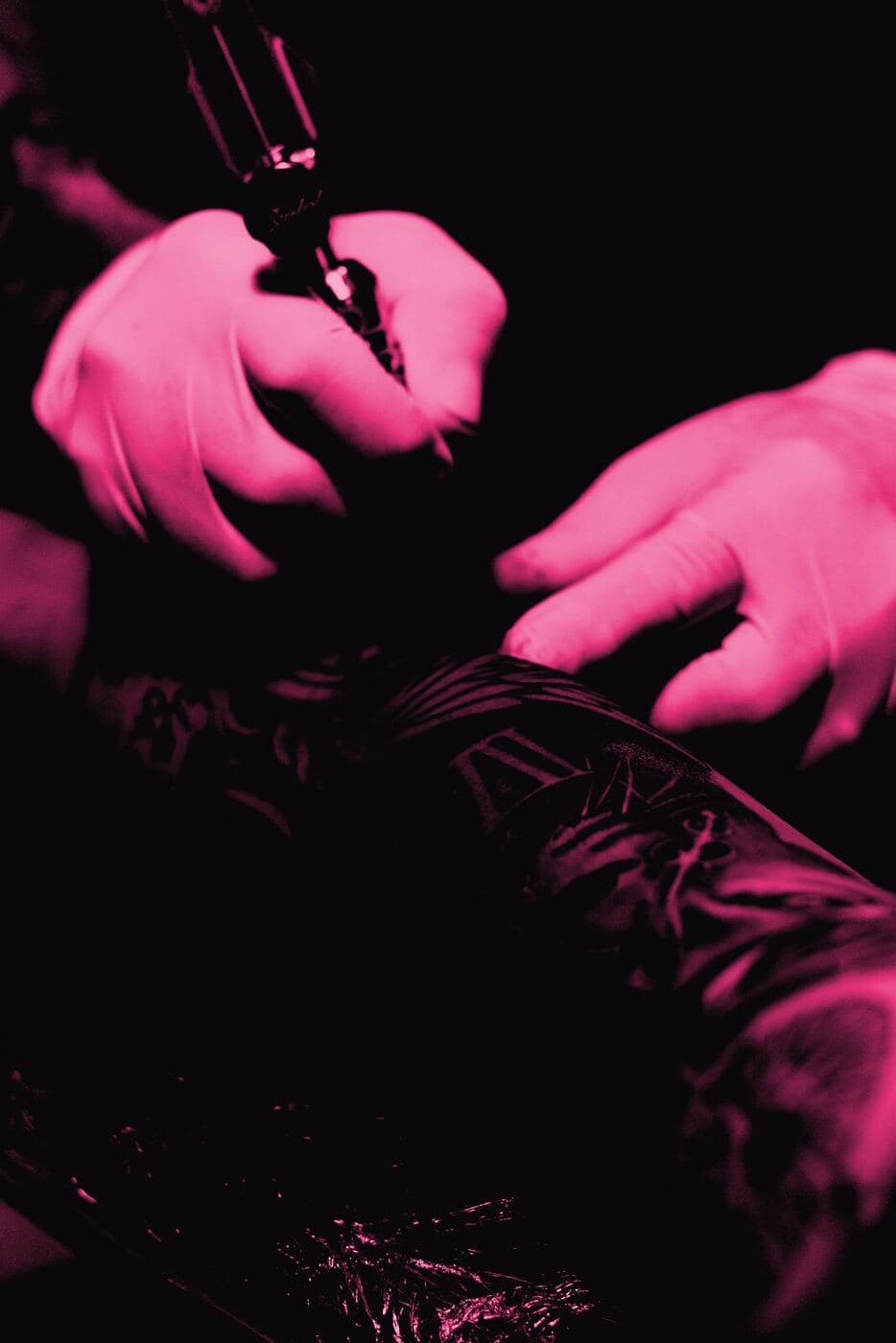 Gloved hands guiding a rotary machine along a stencil