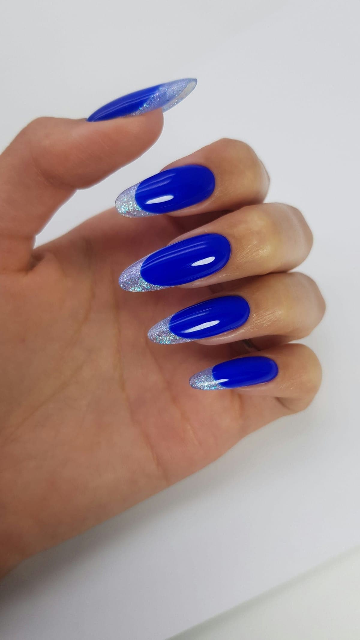 Almond nails in glossy cobalt blue with fine silver French tips