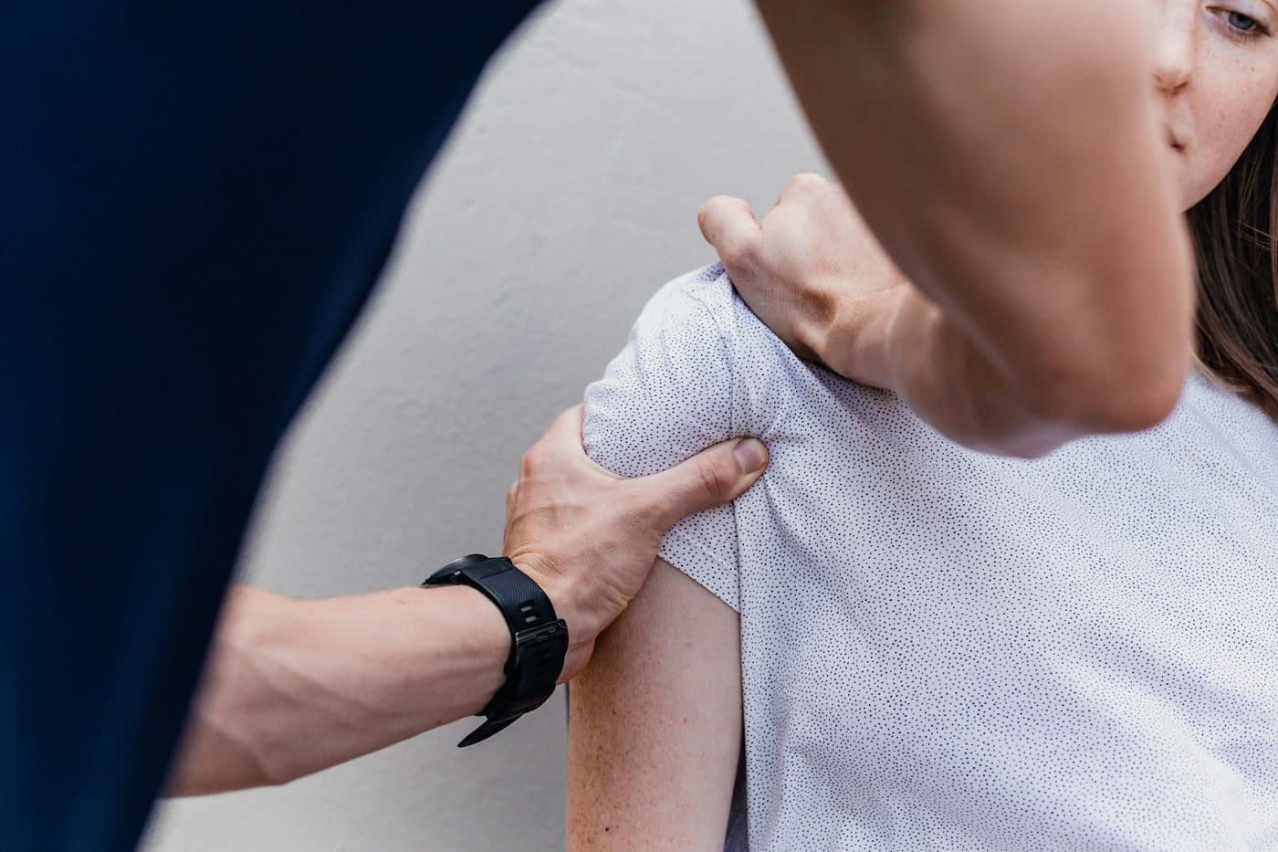 A physiotherapist assessing a woman’s shoulder