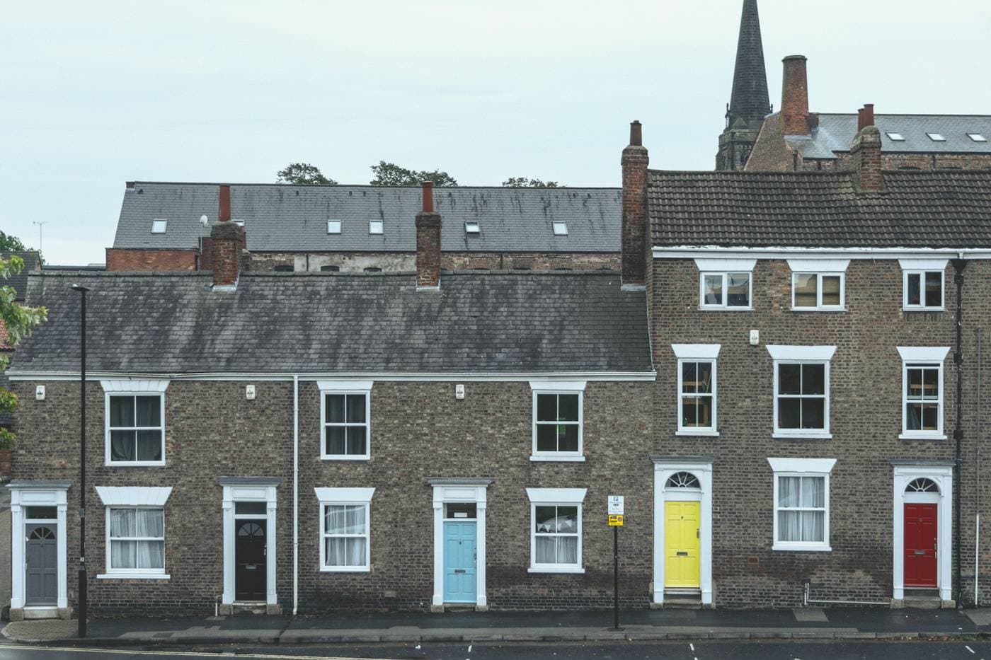 A row of terraced houses with brightly painted front doors