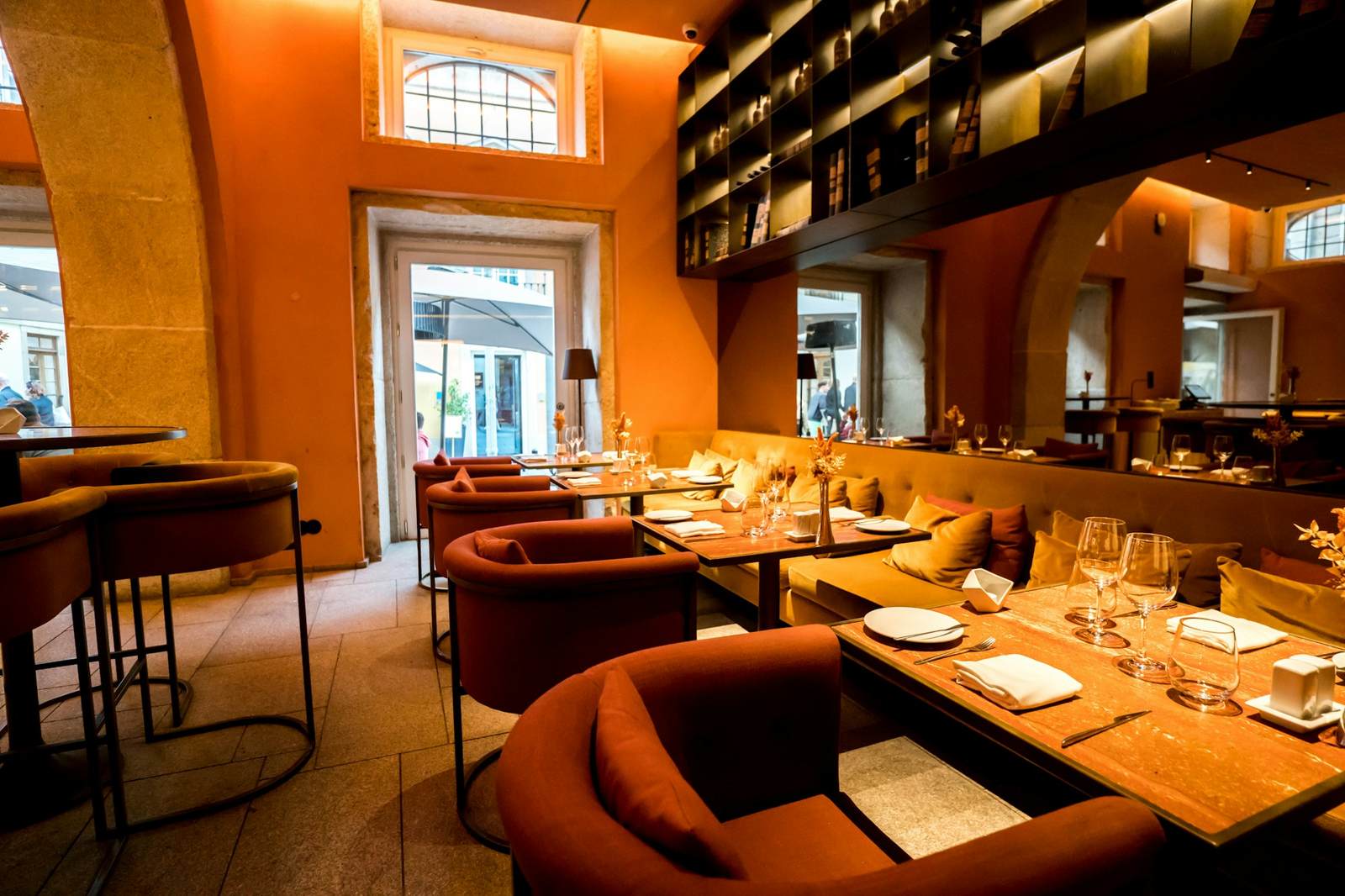 The dining room: terracotta walls, leather banquettes, candlelit tables and shelves of wine