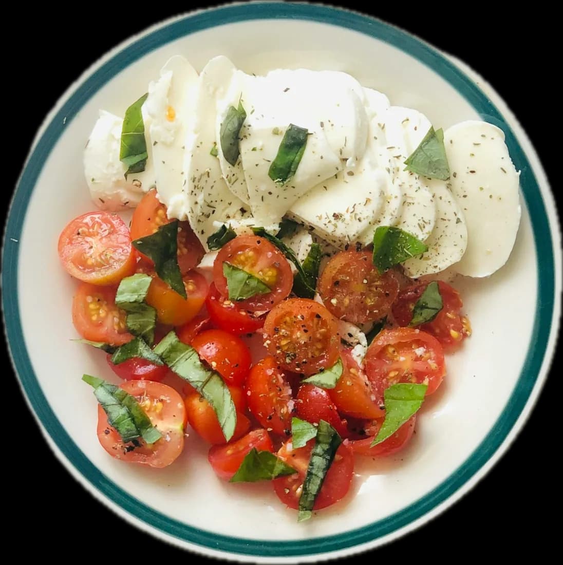 This week’s plate from above: buffalo mozzarella, heritage tomatoes and torn basil on a white plate with a green rim