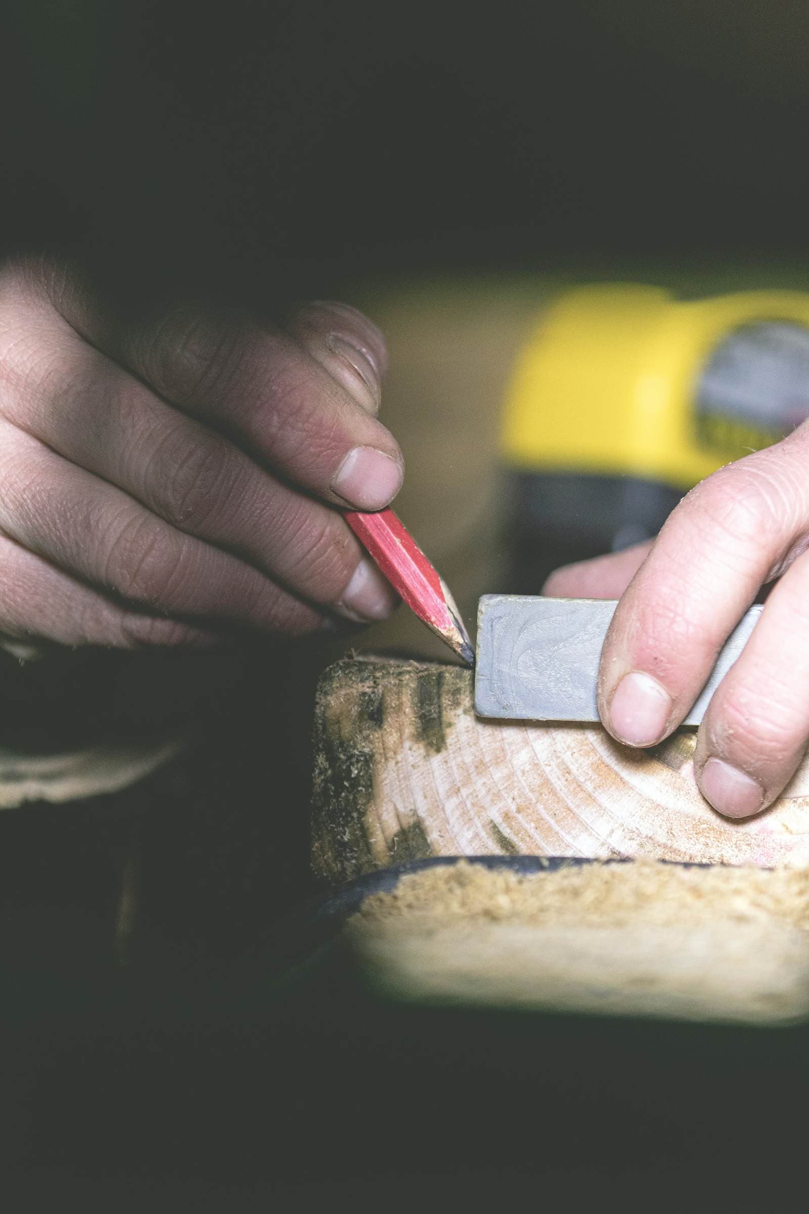 A joiner marking a length of timber with a pencil