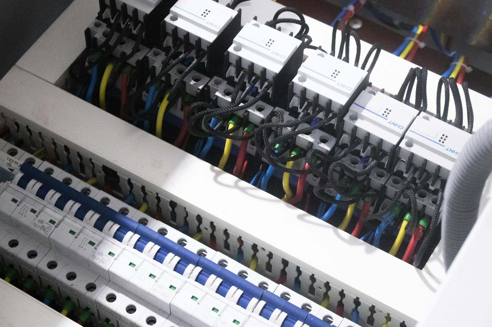 Rows of breakers and neatly dressed cables inside a distribution board